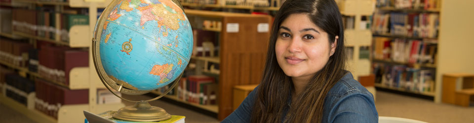 Woman next to globe in library